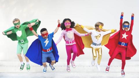 Image of children in superhero costumes and capes