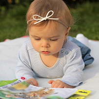 Baby Reading Outdoors