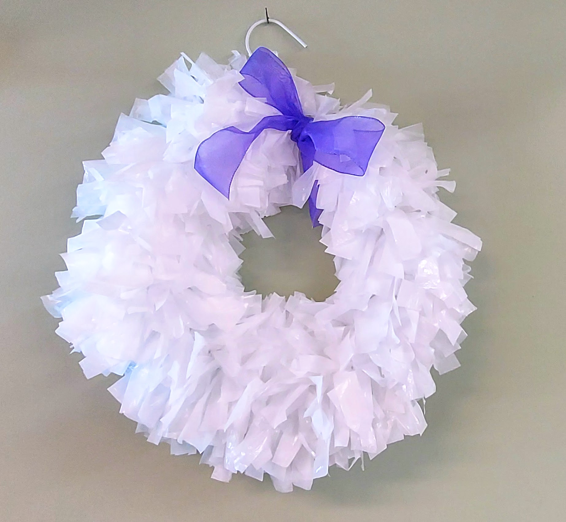 Image of white wreath with a purple bow.