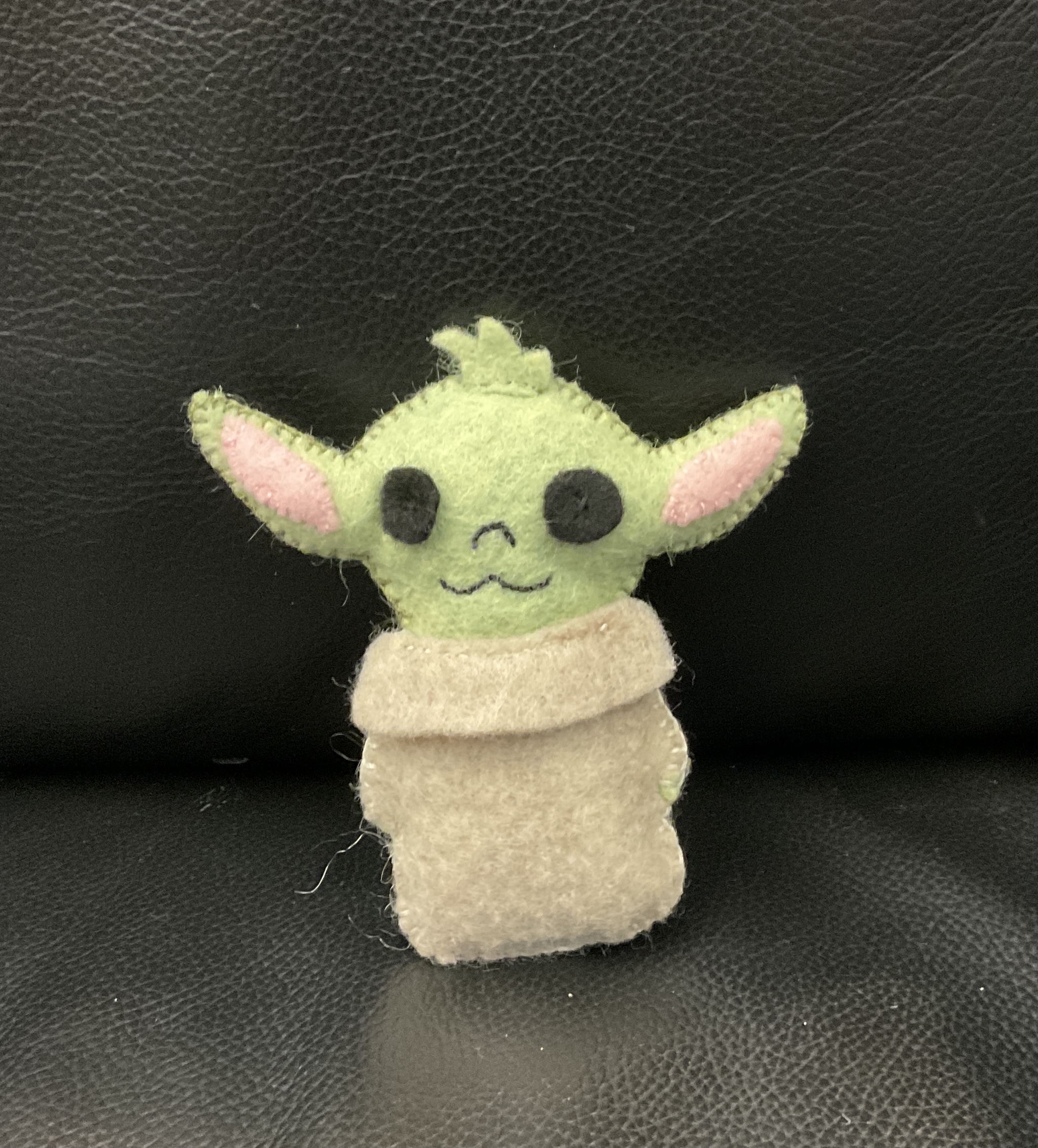 A sewn baby yoda plush.