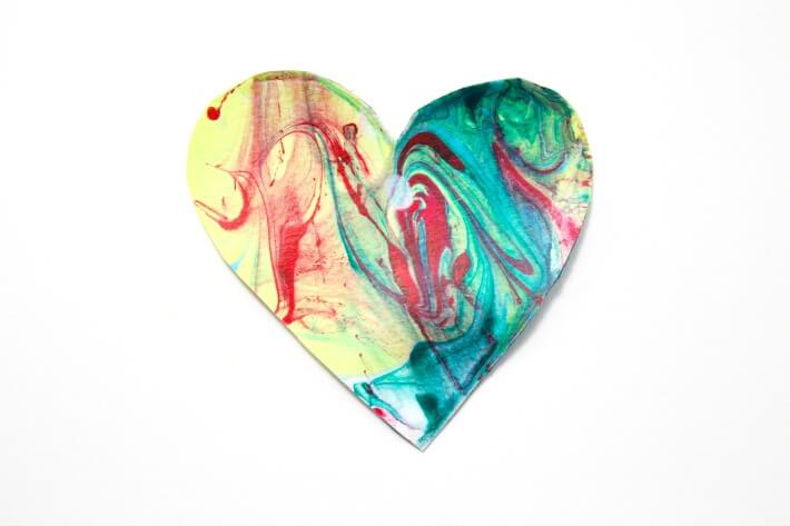 An image of a paper heart with swirls of acrylic paint.