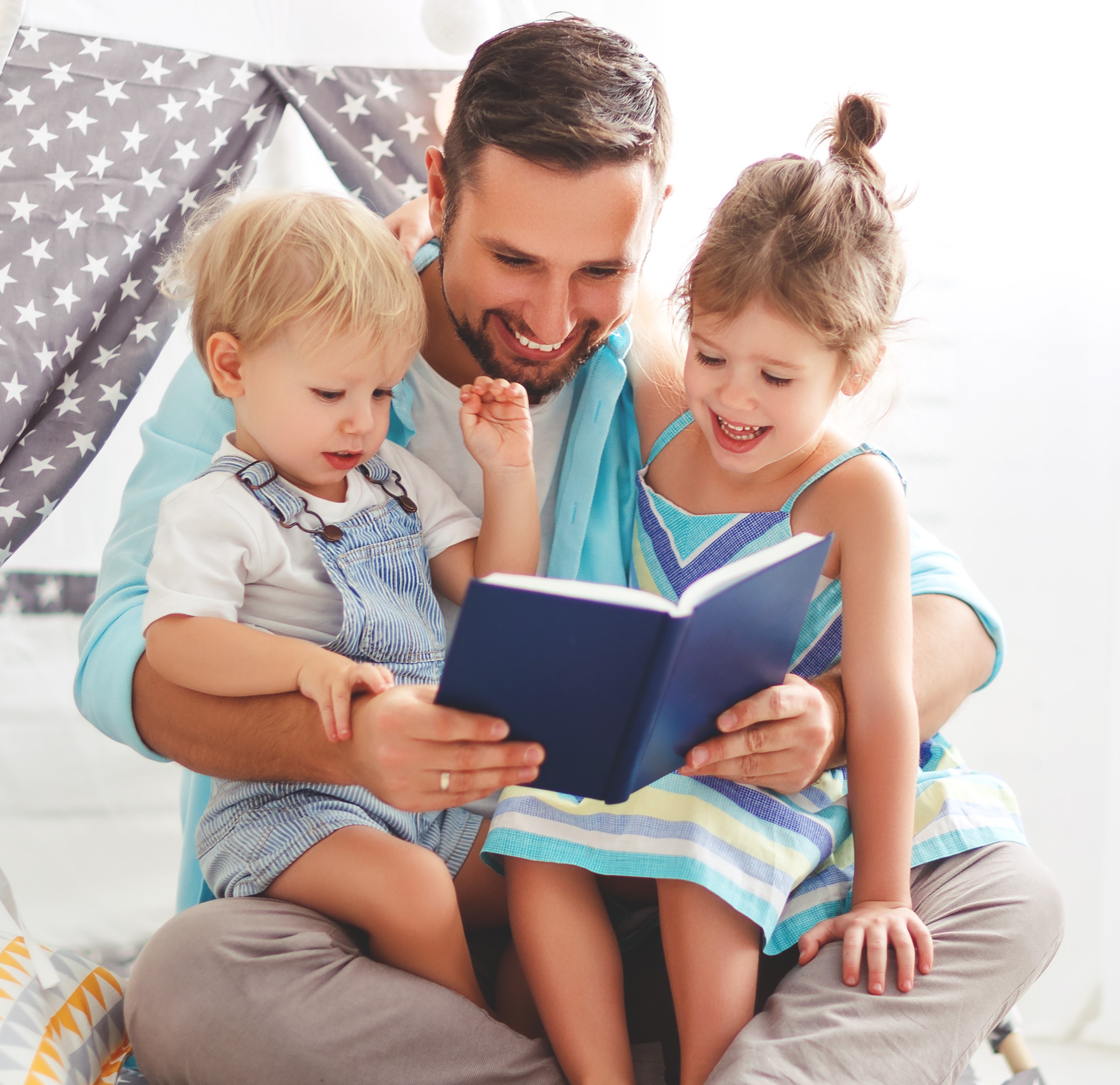 Image of dad reading to kids.