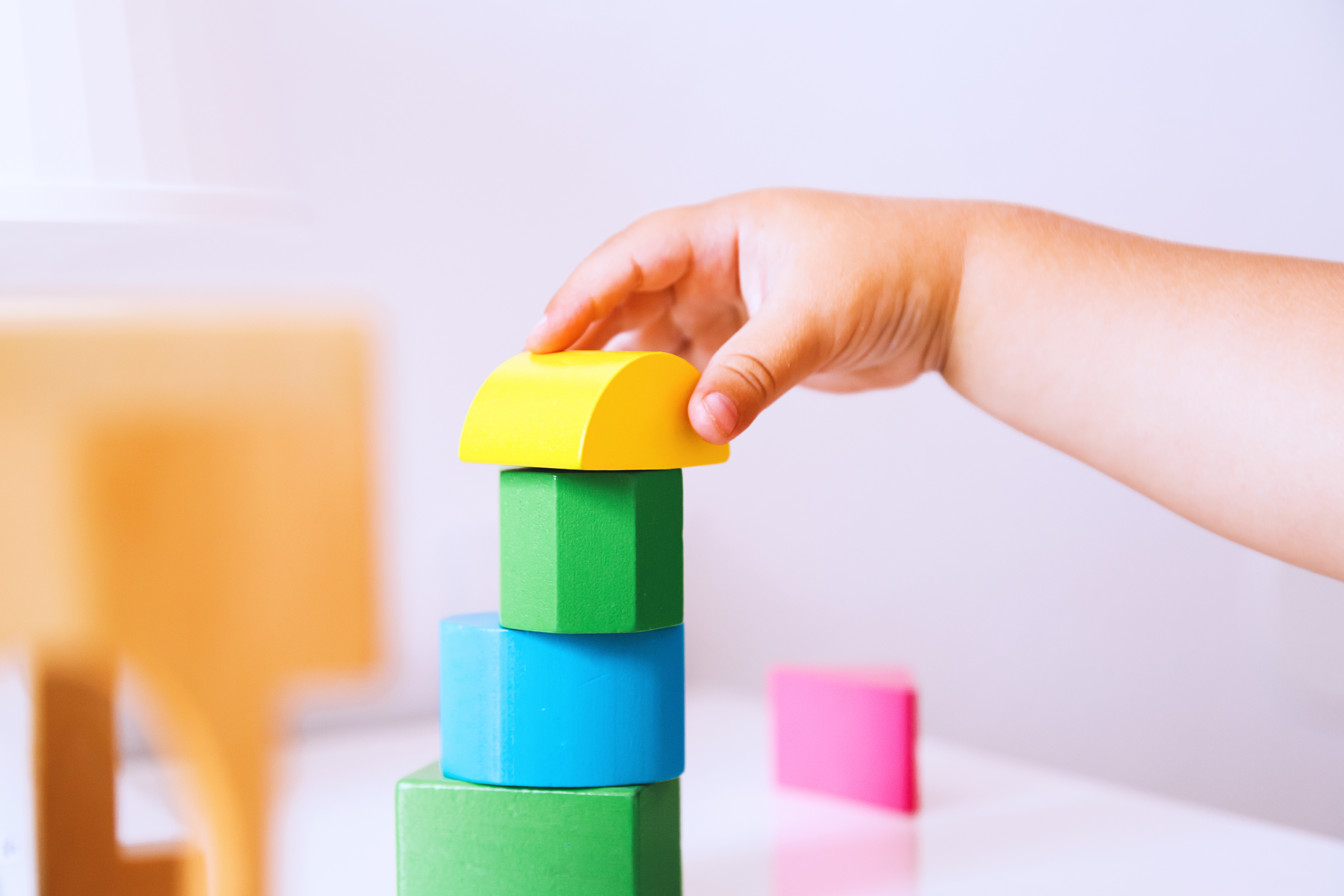 A child stacking play blocks. 