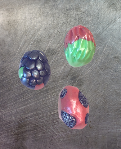 Brightly colored sculpted egg shaped clay magnets.