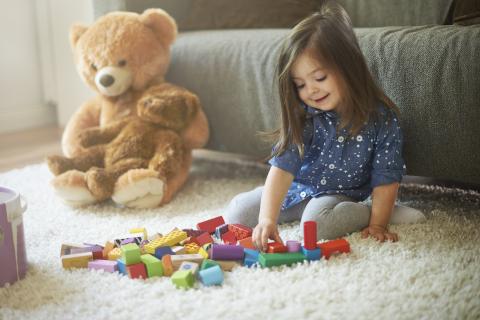 Girl playing with wooden blocks. 