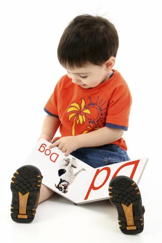 Kid reading a book at family storytime