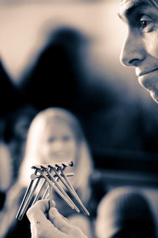 Image of Sam Bartlett holding nails in a stunt. 