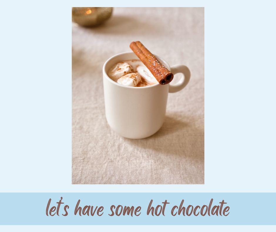 Photo of hot chocolate with a cinnamon stick on a light blue background. A slightly darker blue strip is under the photo with the phrase "let's have some hot chocolate".