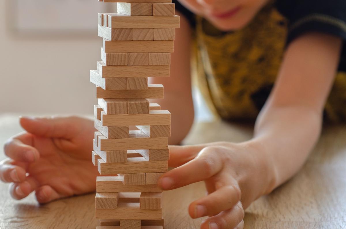 A photo of a child playing jenga. 