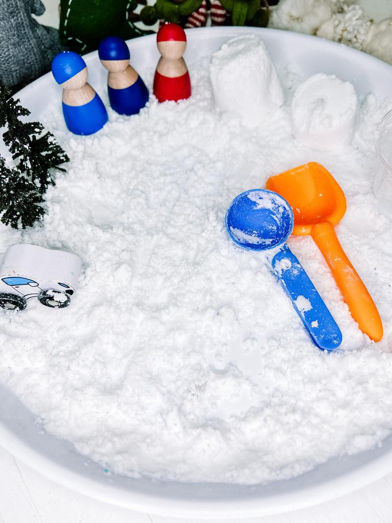 Image of a winter-themed sensory bin with fake snow and shovels